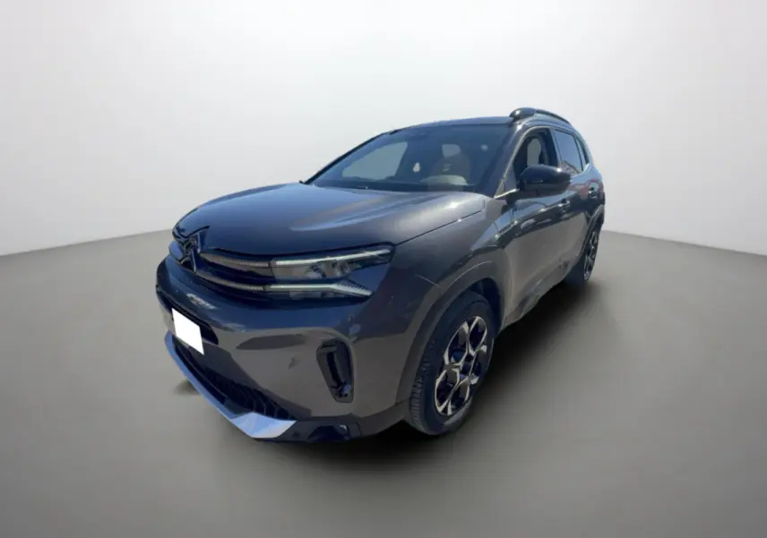 SUV Citroën C5 Aircross gris platinium en 3/4 avant droit avec jantes alu et barres de toit visibles.