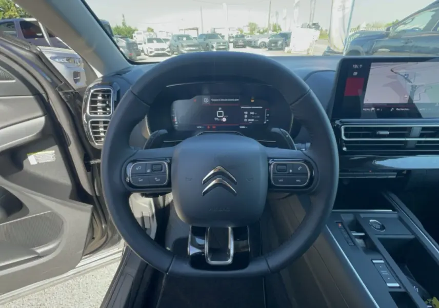 Vue intérieure centrée sur le volant cuir multifonctions du Citroën C5 Aircross 2025 avec écran digital et console moderne.