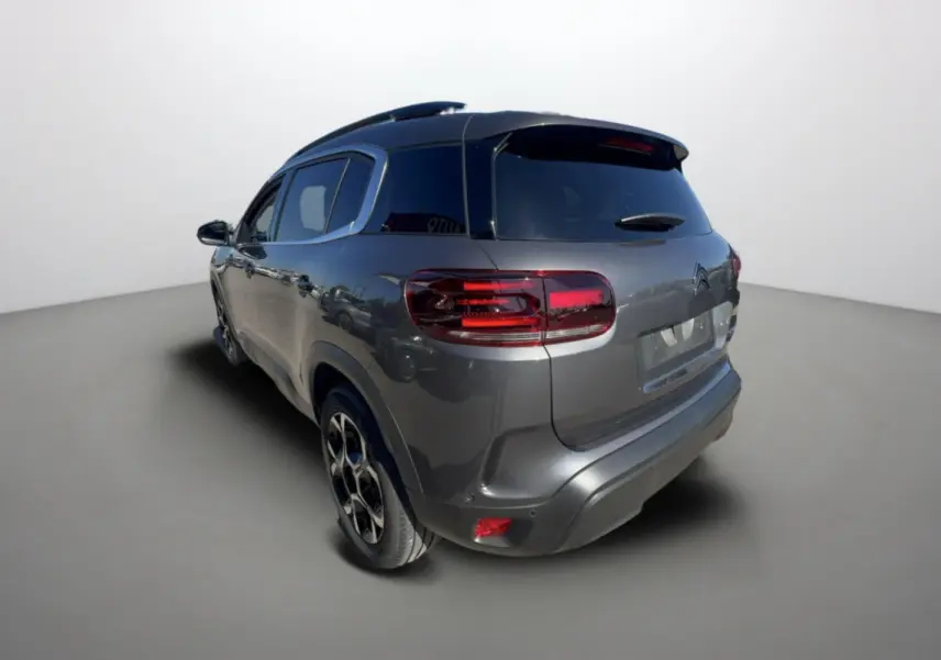 Vue 3/4 arrière droite d’un Citroën C5 Aircross gris platinium avec jantes alu 18 pouces et vitres surteintées.