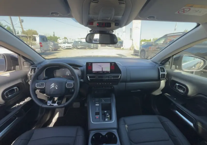 Vue intérieure avant du Citroën C5 Aircross gris platinium, volant multifonctions et écran tactile central avec navigation.