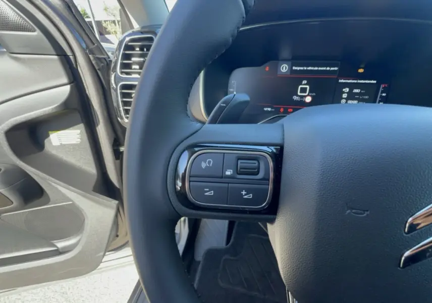 Gros plan sur le volant cuir multifonctions côté gauche du Citroën C5 Aircross 2025, intérieur gris platinium.