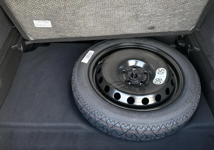 Gros plan sur la roue de secours temporaire noire dans le coffre du Renault Symbioz E-Tech Full Hybrid 2025.