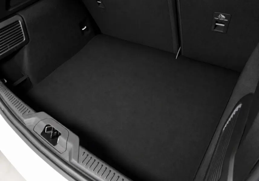 Vue du coffre ouvert d'une Ford Focus blanche 2024, mettant en valeur l'espace de chargement noir et les finitions intérieures.