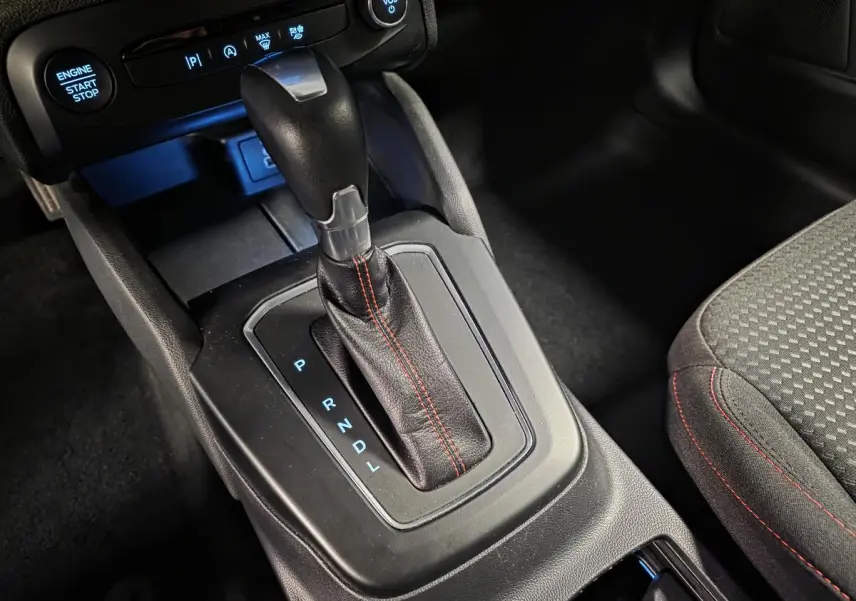 Gros plan sur le levier de vitesses automatique en cuir noir avec surpiqûres rouges de la Ford Focus ST Line 2024.