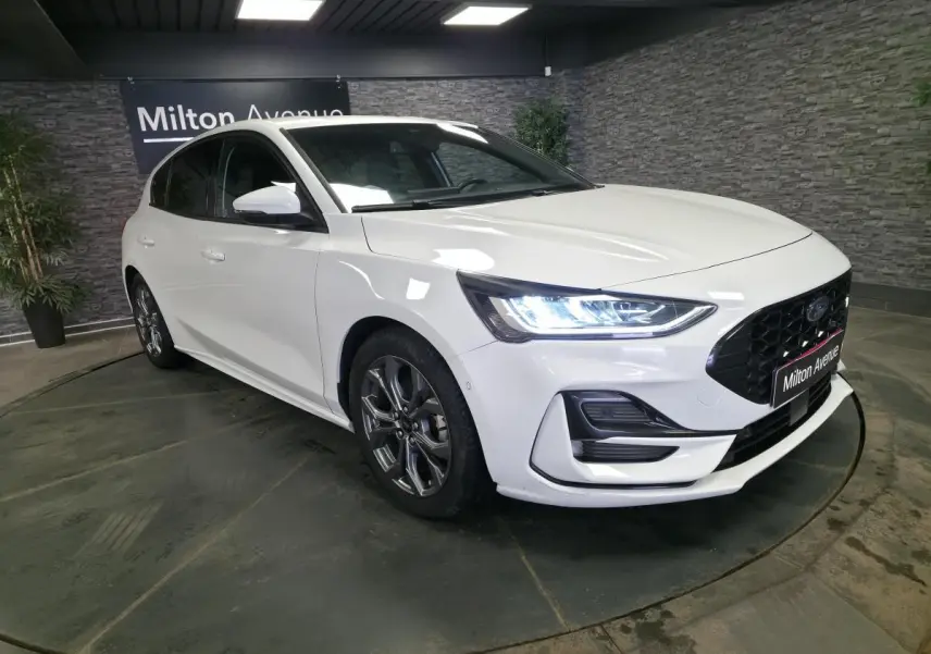 Ford Focus 2024 blanche vue 3/4 avant droit, avec calandre noire ST-Line et jantes alliage 17 pouces.