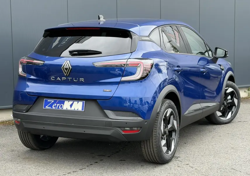 Vue 3/4 arrière droite du Renault Captur 2026 en Bleu Iron avec jantes aluminium noires et vitres surteintées.