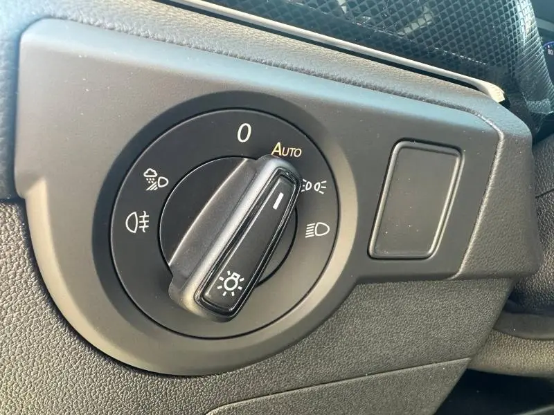 Gros plan sur la commande des phares du Volkswagen T-Cross 2026, bouton noir avec options d'éclairage automatique.
