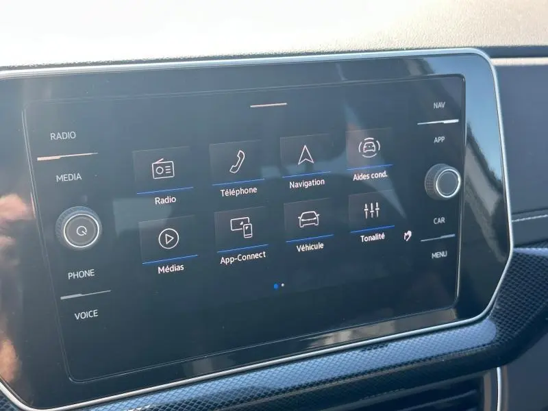 Écran tactile central du Volkswagen T-Cross 2026 affichant le menu multimédia et aides à la conduite, intérieur noir.