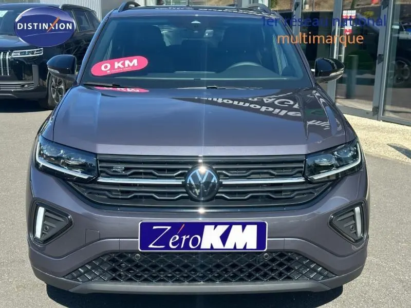 Vue frontale d'un Volkswagen T-Cross 1.0 TSI R-Line gris cendré métallisé avec calandre noire et feux LED.