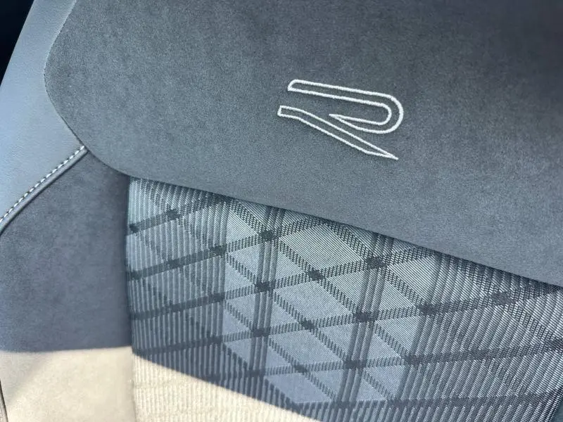 Détail du siège avant gris R-Line avec logo brodé et tissu à motif géométrique sur Volkswagen T-Cross 2026.
