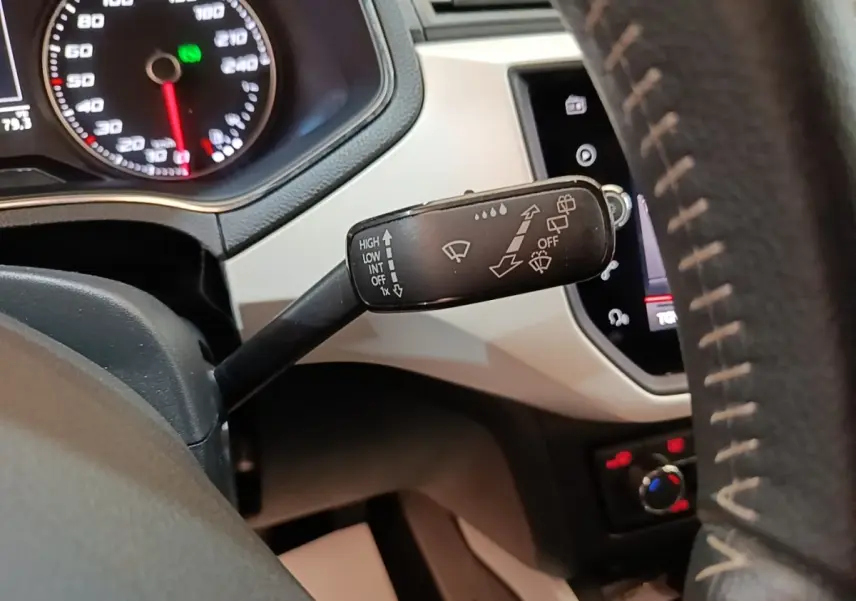 Gros plan sur la commande d’essuie-glace à gauche du volant dans l’habitacle gris clair du SEAT Arona 2019.