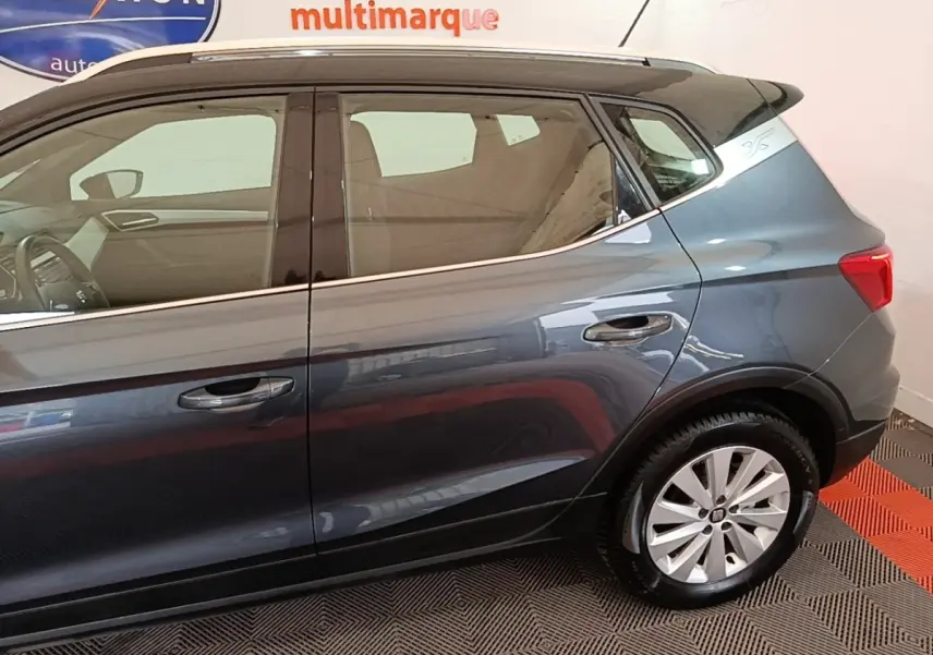 Vue latérale droite du SEAT Arona gris clair, mettant en valeur les jantes alliage et les lignes de la carrosserie.