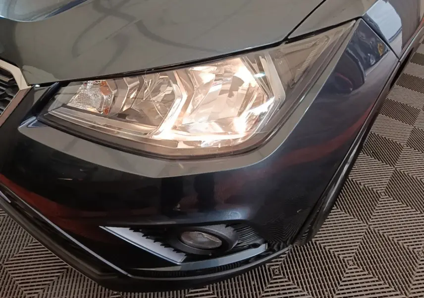 Gros plan sur le phare avant droit et le pare-chocs gris foncé d'un SEAT Arona 2019, avec antibrouillard intégré.