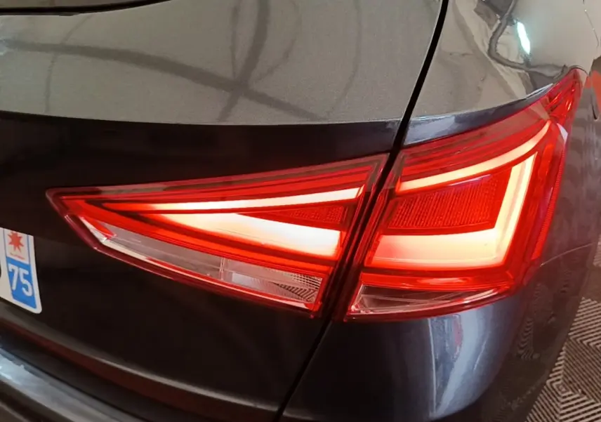 Gros plan sur le feu arrière droit rouge d’un SEAT Arona gris clair, avec une partie de la plaque d’immatriculation visible.