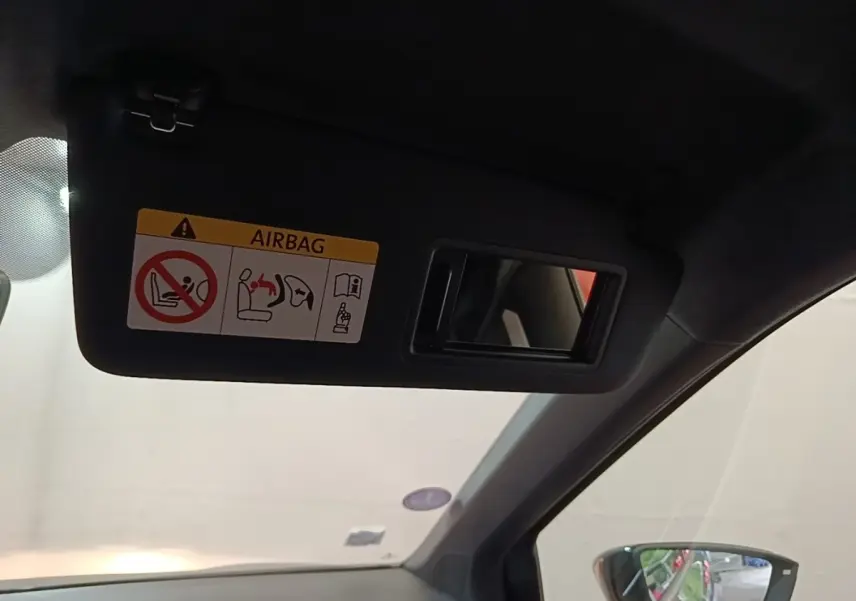 Détail de pare-soleil avec miroir et avertissement airbag à l'intérieur d'un SEAT Arona 2019, côté conducteur.