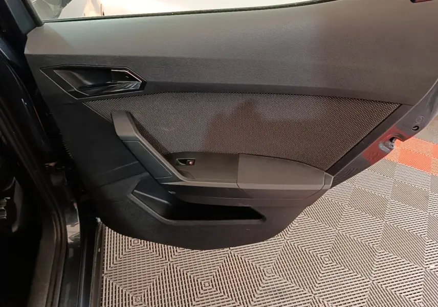 Vue rapprochée de la porte arrière gauche noire du SEAT Arona 2019, avec poignée intégrée et panneau texturé.