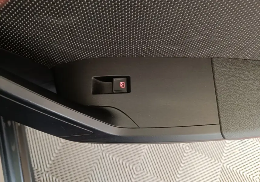 Bouton de verrouillage centralisé sur la porte intérieure côté conducteur d'un SEAT Arona gris clair.