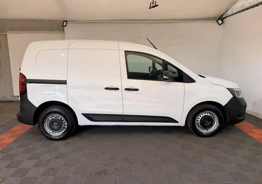 Profil côté gauche d’un Renault Kangoo blanc 2022 utilitaire avec jantes acier et protections noires sur les bas de caisse.