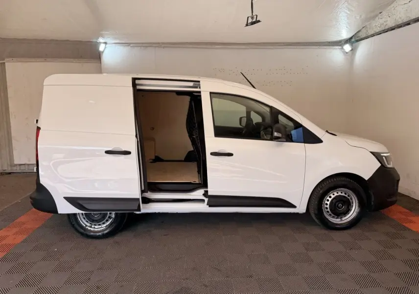 Vue latérale droite d’un Renault Kangoo blanc 2022 avec porte coulissante ouverte, intérieur utilitaire visible.