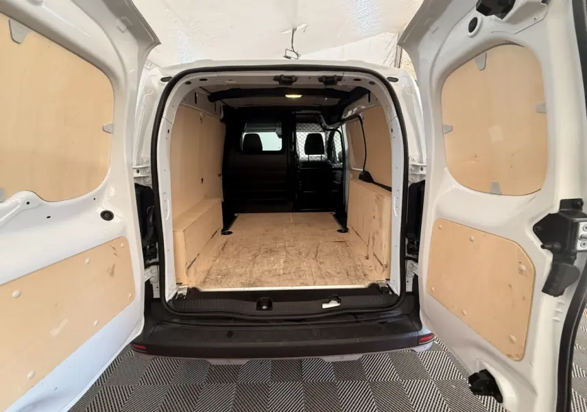 Vue arrière ouverte du Renault Kangoo blanc 2022, montrant l’espace de chargement avec panneaux en bois et séparation intérieure.