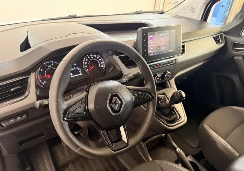 Vue intérieure du poste de conduite du Renault Kangoo 2022 avec volant, tableau de bord et écran tactile central.