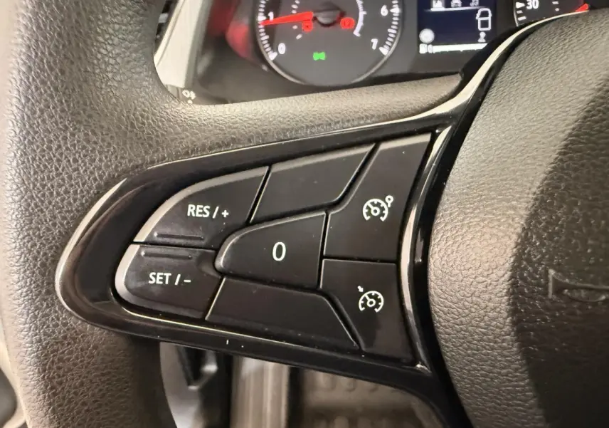 Gros plan sur les commandes au volant du Renault Kangoo 2022, boutons noirs avec fonctions régulateur de vitesse visibles.