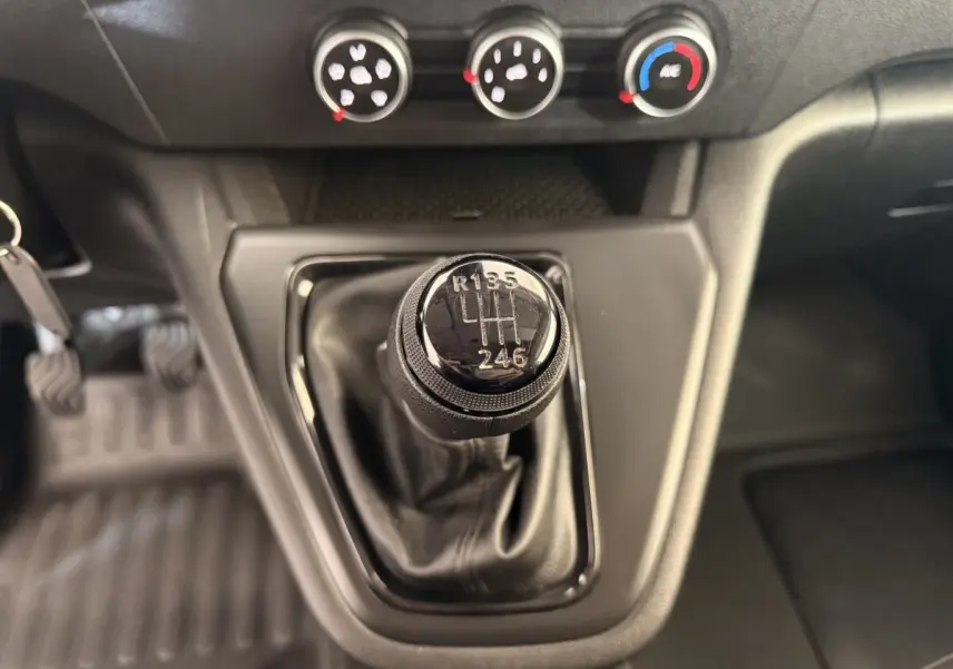 Le levier de vitesses manuel du Renault Kangoo 2022 en gros plan, avec commandes de climatisation visibles en arrière-plan.