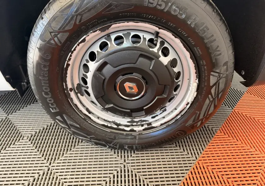 Gros plan sur la roue avant droite d’un Renault Kangoo blanc 2022, jante acier avec peinture écaillée et pneu Continental.