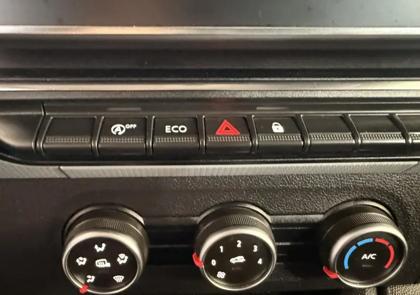 Image intérieure montrant la console centrale du Renault Kangoo 2022 avec commandes climatisation et boutons fonctionnels.