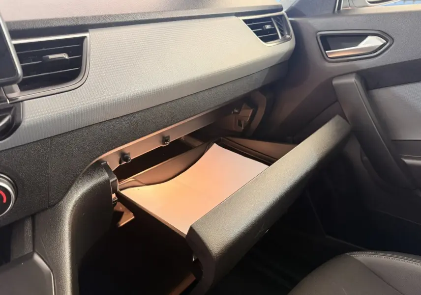 Intérieur du Renault Kangoo 2022, vue côté passager sur la boîte à gants ouverte avec un document blanc visible.