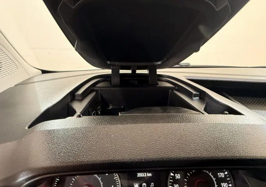 Vue rapprochée de la console centrale ouverte et du tableau de bord noir du Renault Kangoo blanc 2022.