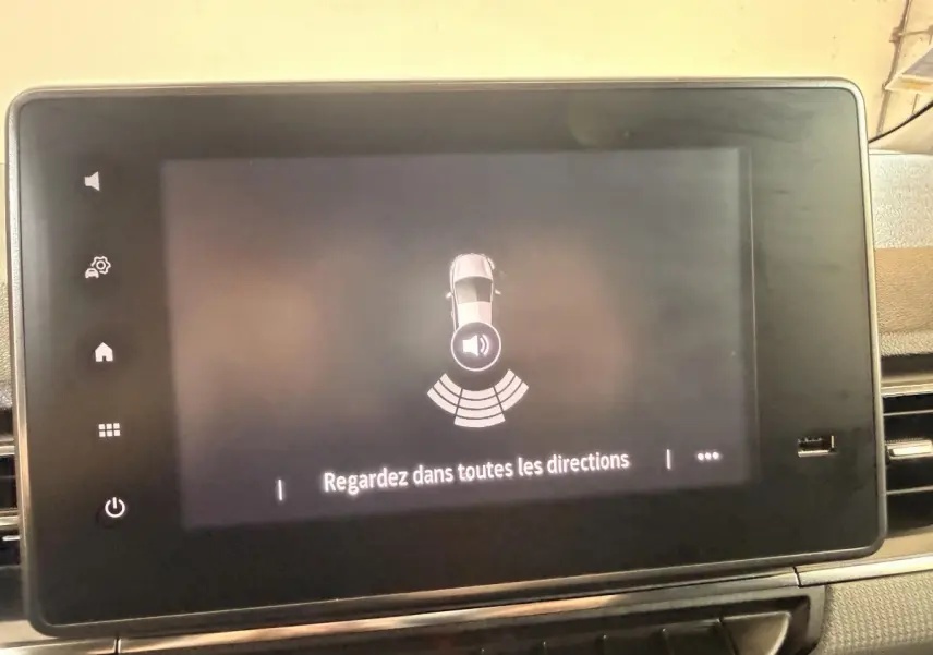 Écran tactile intérieur du Renault Kangoo 2022 montrant l'alerte de proximité avec message "Regardez dans toutes les directions".