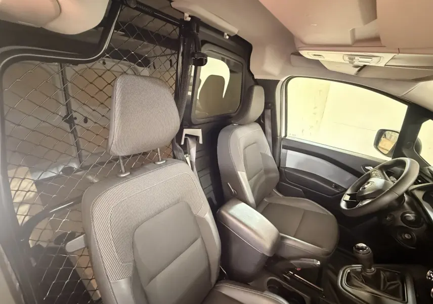 Vue intérieure côté conducteur du Renault Kangoo 2022, montrant les sièges gris et la cloison métallique séparatrice.