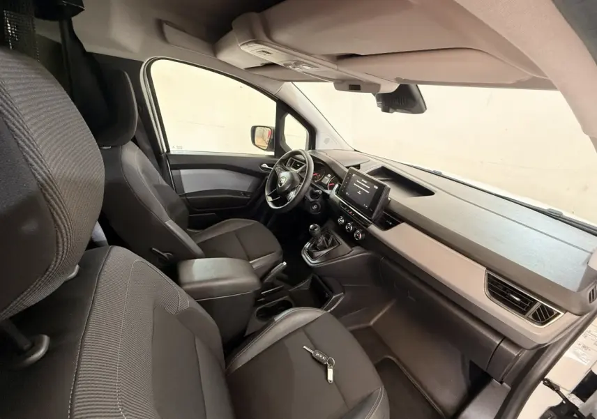 Vue intérieure côté passager du Renault Kangoo 2022, montrant les sièges noirs et la console avec écran tactile.