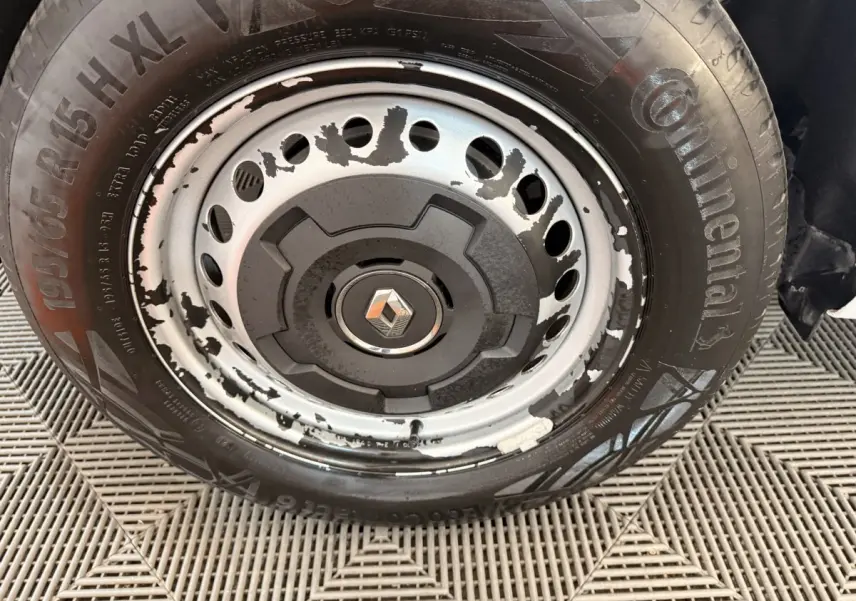 Gros plan sur la roue avant droite d’un Renault Kangoo blanc 2022, jante acier avec peinture écaillée.