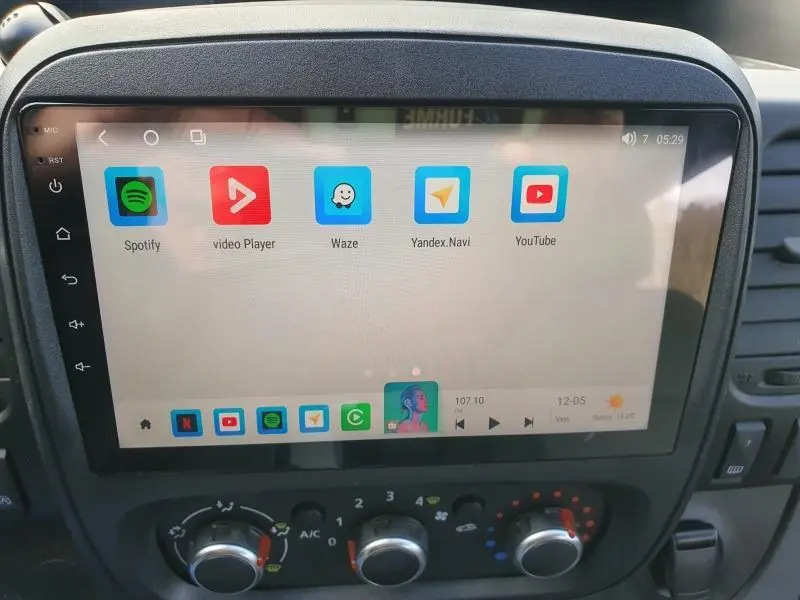 Écran tactile central du Renault Trafic Fourgon blanc, affichant des applications multimédia, avec commandes de climatisation en dessous.