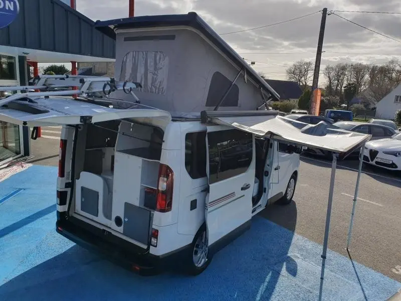 Vue 3/4 arrière droite du Renault Trafic Fourgon blanc Glacier 2022 avec toit relevé et auvent déployé.