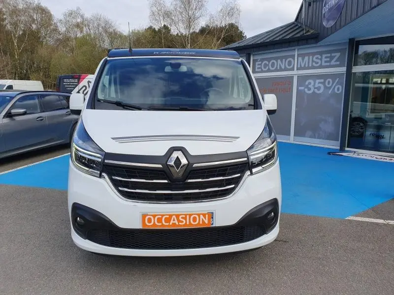 Vue frontale d'un Renault Trafic Fourgon blanc Glacier avec calandre noire et plaque "OCCASION" orange.