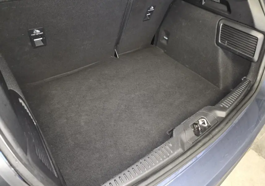 Vue plongeante sur le coffre vide de la Ford Focus 2024 bleu azur, avec revêtement noir et finitions soignées.