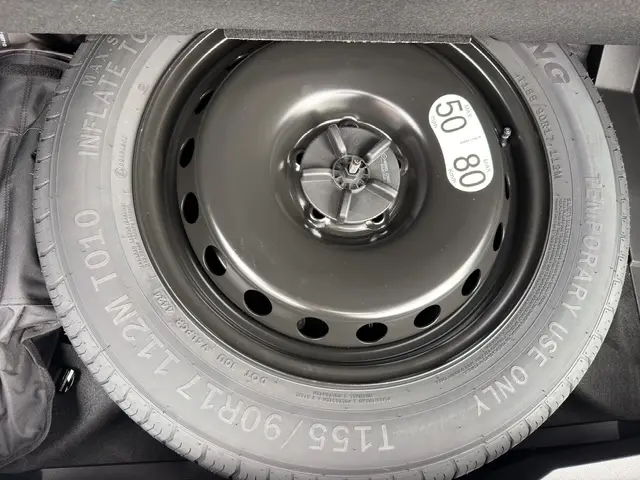 Gros plan sur la roue de secours temporaire noire dans le coffre du Renault Austral bleu 2026, version techno full hybrid.