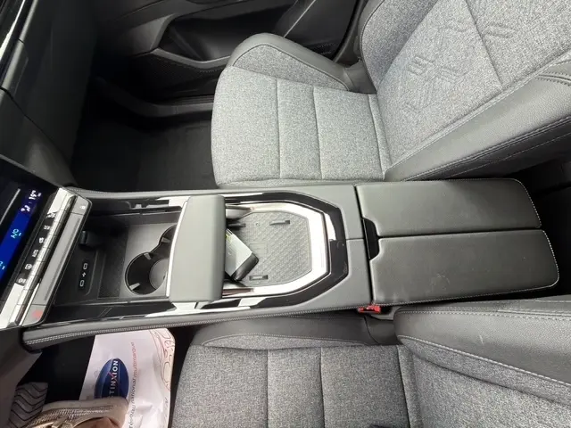 Vue intérieure rapprochée du Renault Austral 2026, montrant l'accoudoir central avant en cuir noir et sièges tissu gris.