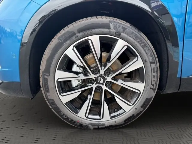 Gros plan sur la roue avant droite du Renault Austral bleu, mettant en valeur la jante alliage RS au design moderne.