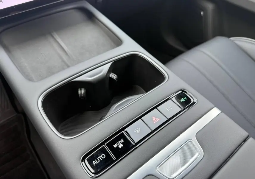 Gros plan sur la console centrale noire avec porte-gobelets et boutons de modes de conduite du JAECOO J7 hybride.