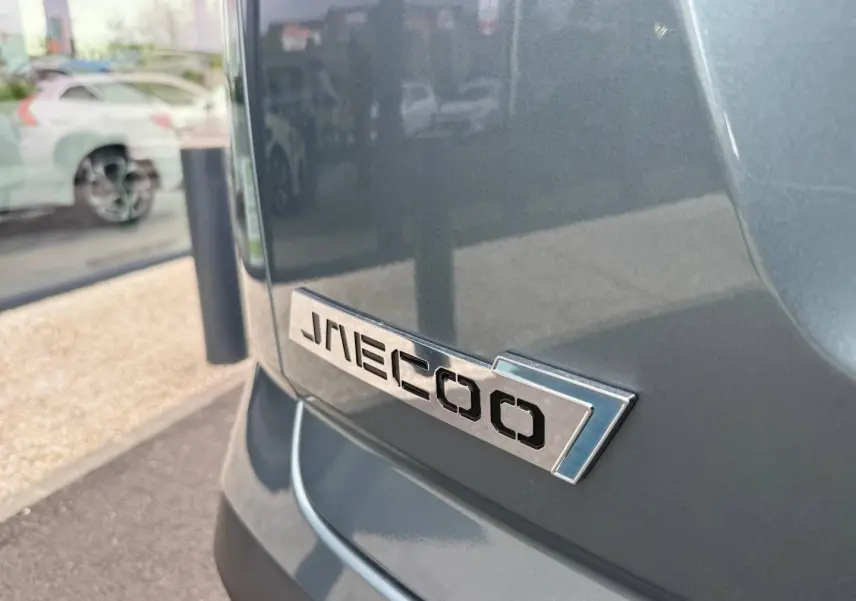 Gros plan sur l'arrière droit du JAECOO J7 olive grey métal avec logo chromé sur la carrosserie.
