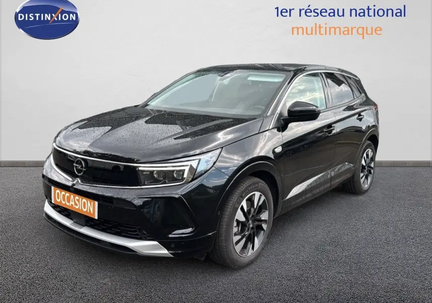 Opel Grandland noir en 3/4 avant droit, hybride rechargeable, jantes bi-ton et calandre moderne sous la pluie.
