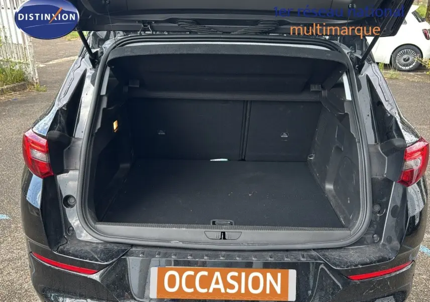 Coffre ouvert d’un Opel Grandland noir 2024, vue arrière montrant l’espace de chargement vide et les feux arrière rouges.
