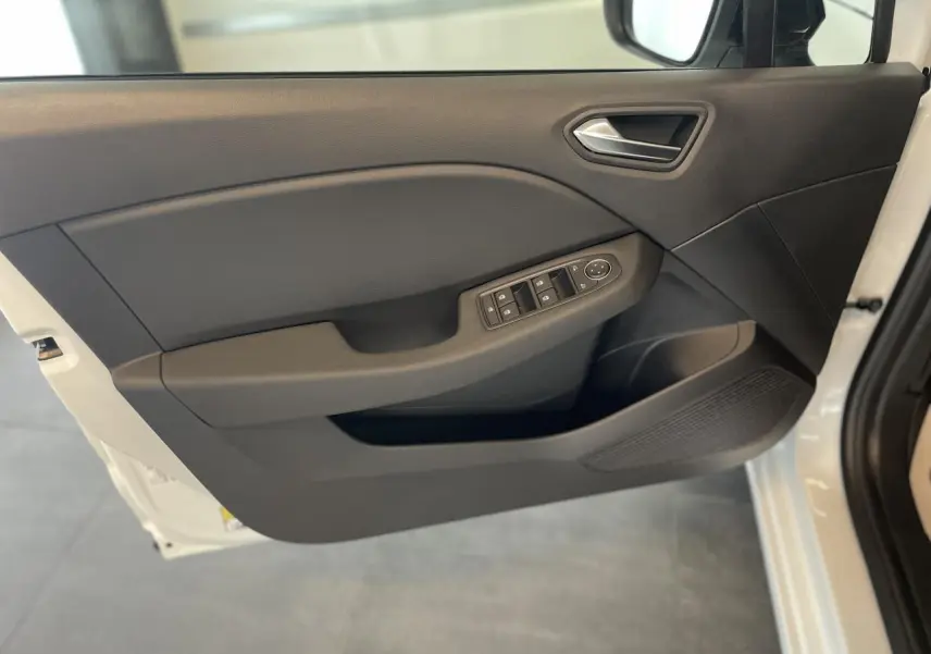 Porte avant gauche ouverte d'une Renault Clio blanche, montrant la garniture noire avec commandes électriques des vitres.