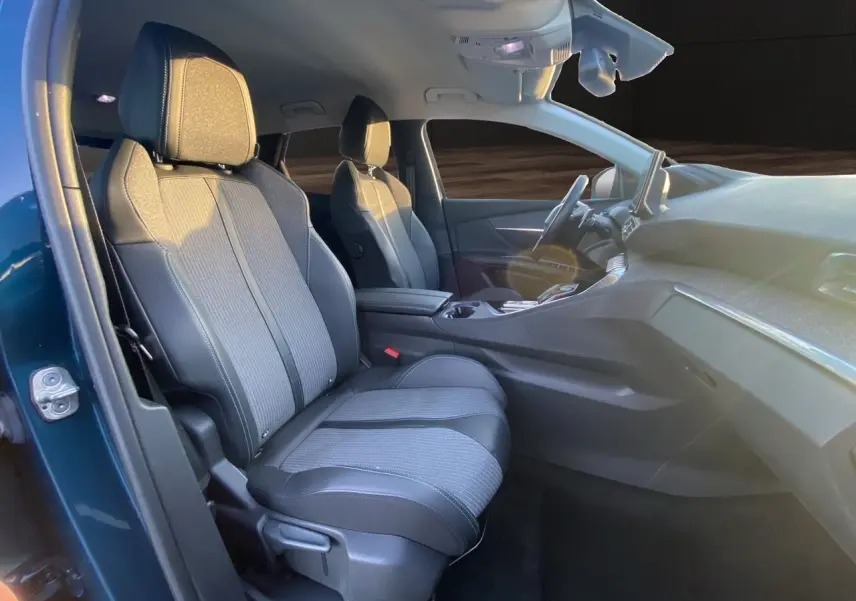 Vue intérieure côté gauche du Peugeot 3008 Bleu Celebes, mettant en valeur les sièges en tissu et cuir gris noir.