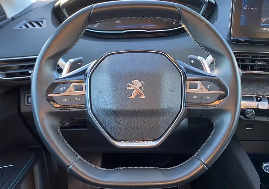 Vue rapprochée du volant cuir noir du Peugeot 3008 2021 avec commandes intégrées et tableau de bord numérique.