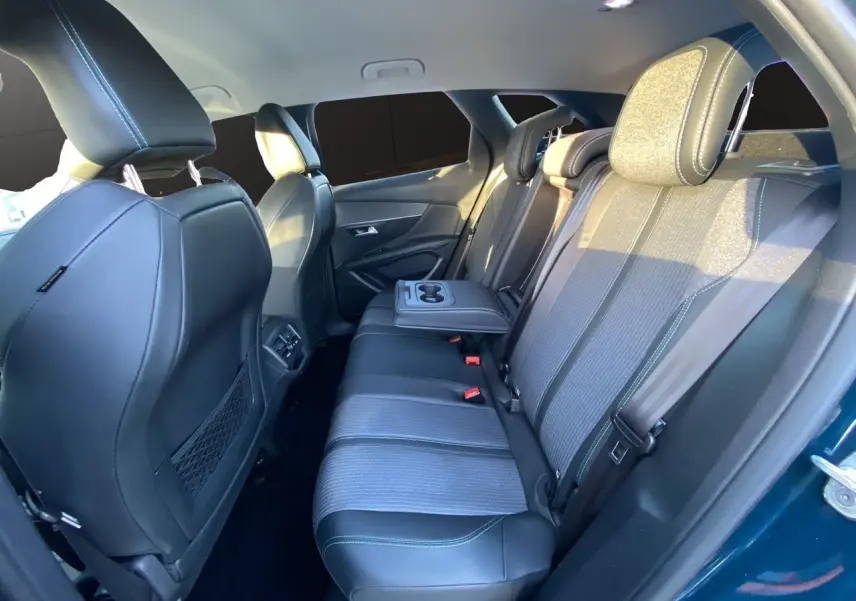 Vue intérieure arrière côté droit du Peugeot 3008 Bleu Celebes, sièges en cuir et tissu avec accoudoir central rabattable.
